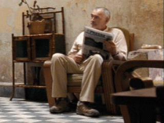 Michael G. Wilson. Man Sitting in Chair in Haitian Hotel Lobby